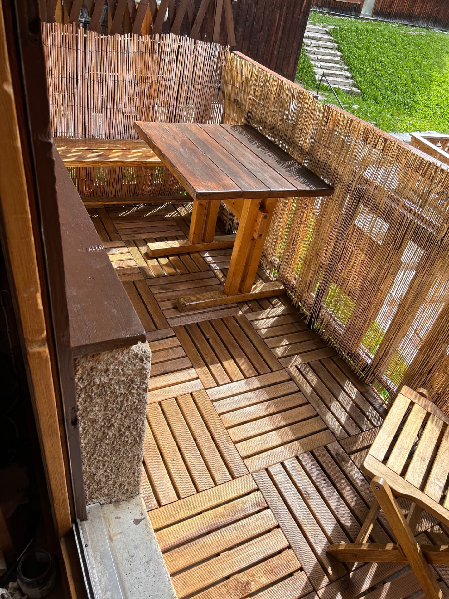 Balcon plein sud en bois avec table, banc et claustra