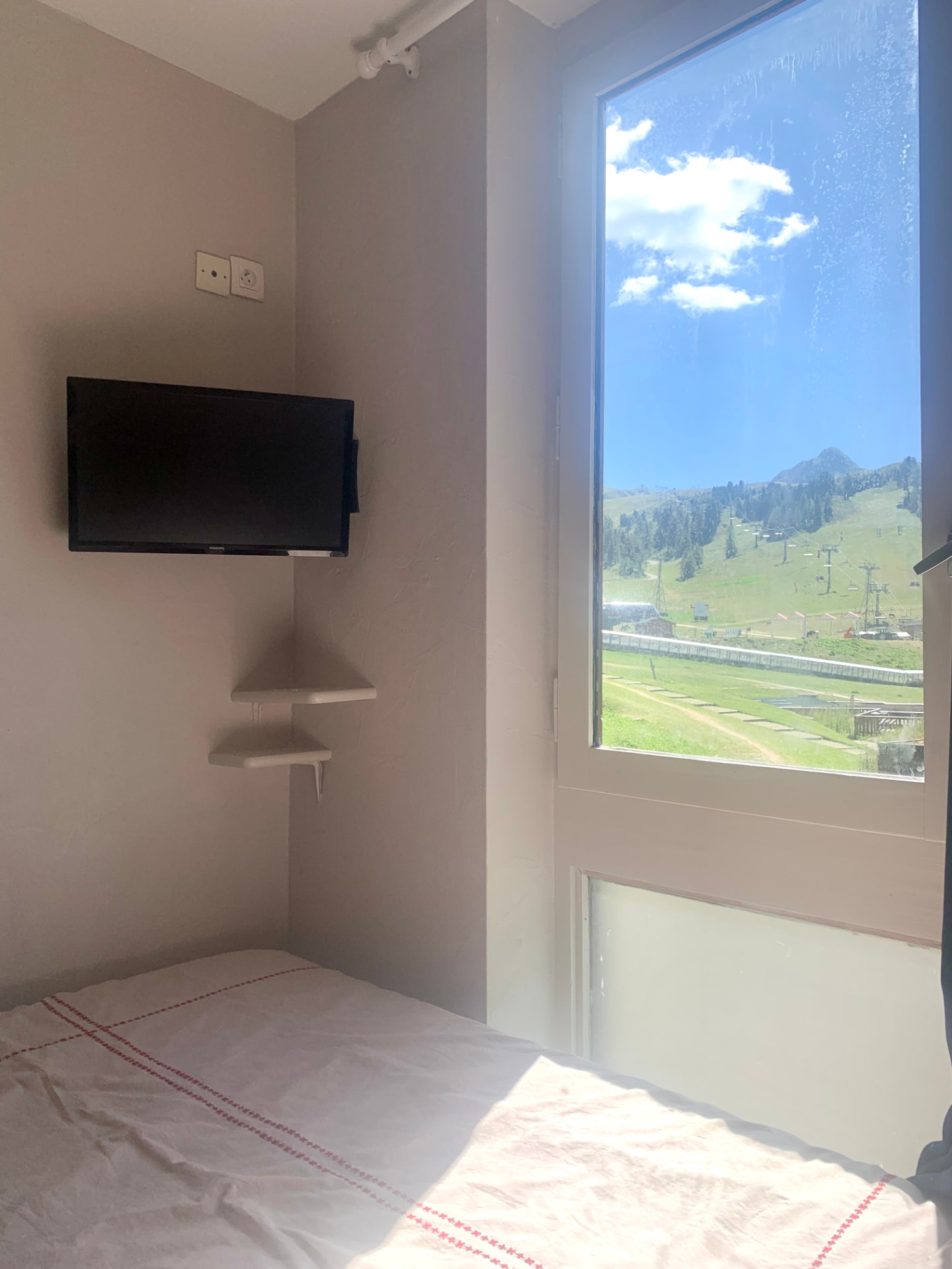 Chambre côté fenêtre avec téléviseur mural et vue sur la montagne
